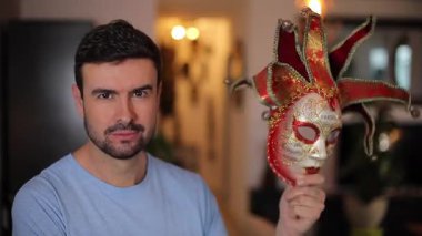 Genç yakışıklı adam karnavalda maske takıyor.