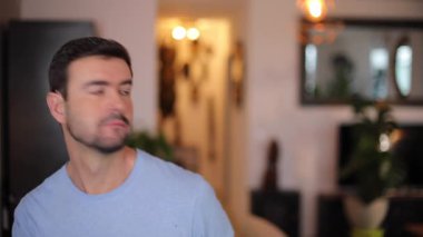 Evdeki oturma odasında jest yapan bir adam.