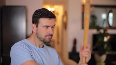 Yakışıklı adam beyzbol sopasıyla oynuyor.