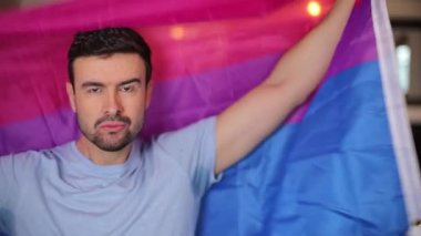 Elinde lgbt bayrağı olan yakışıklı gay adamın portresi.
