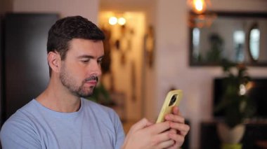 Genç adam akıllı telefonuyla mesaj yolluyor.