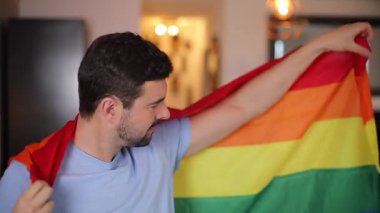 Gökkuşağı bayrağını sallayan yakışıklı, gururlu adam. 