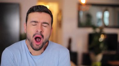 Evde esneyen genç bir adamın portresi.