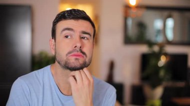 Yakın plan. Şok olmuş yüzlü genç sakallı adamın portresi.