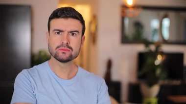 Genç adamın yüzünde kızgın bir ifade var.