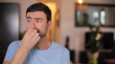 Evdeki oturma odasında şaşırmış bir adam var.