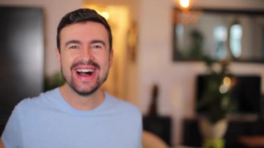 Genç adam evdeki oturma odasında bağırıyor.