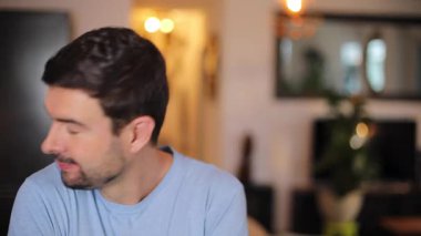 Evdeki oturma odasında sakallı yakışıklı bir adamın portresi.