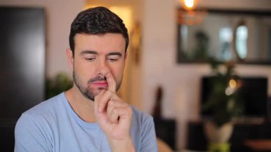 Evdeki oturma odasında sıkılmış bir adam.