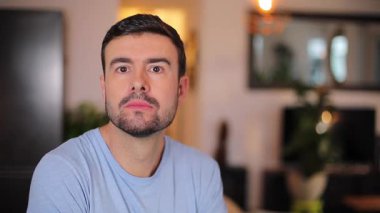 Şok olmuş bir adam evdeki oturma odasına bakıyor.