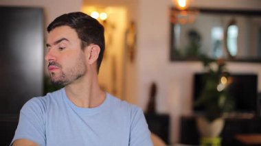 Evdeki oturma odasında sakallı genç bir adamın portresi.