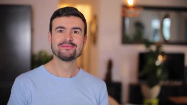 Odada sakallı yakışıklı bir adam var.