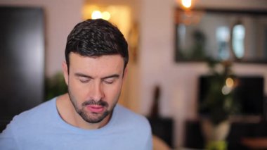 Odada sakallı yakışıklı bir adam var.