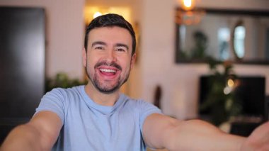 Odada sakallı yakışıklı bir adam var.