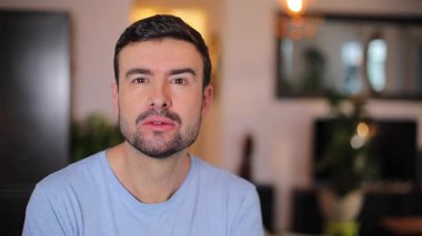 Odada sakallı yakışıklı bir adam var.