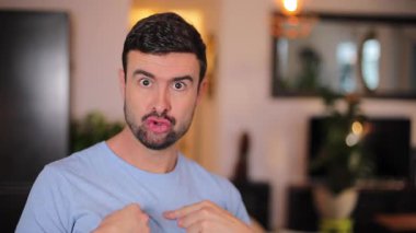 Odada sakallı yakışıklı bir adam var.