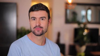 Odada sakallı yakışıklı bir adam var.