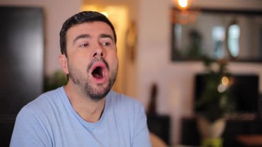 Odada sakallı yakışıklı bir adam var.