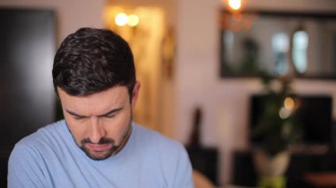 Odada sakallı yakışıklı bir adam var.