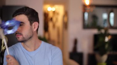 Karnaval maskesi tutan yakışıklı adam.