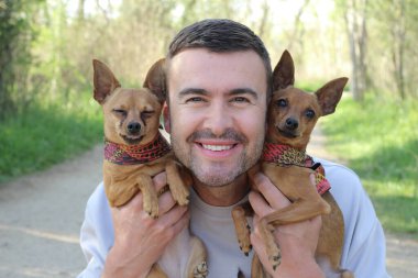 Ormanda insan ve iki sevimli köpeğin portresi.