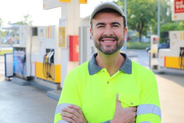 Kollarını kavuşturmuş duran gülümseyen yakışıklı adamın portresi.