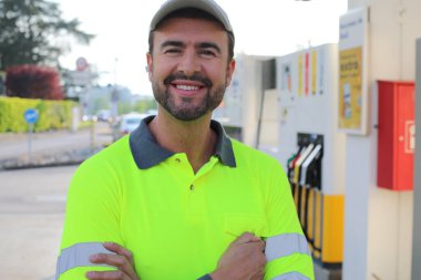 Kollarını kavuşturmuş duran gülümseyen yakışıklı adamın portresi.