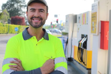 Kollarını kavuşturmuş duran gülümseyen yakışıklı adamın portresi.