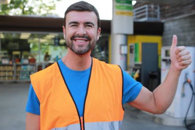 Garajda bir numarayı gösteren mutlu bir jest yapan genç İspanyol adam..
