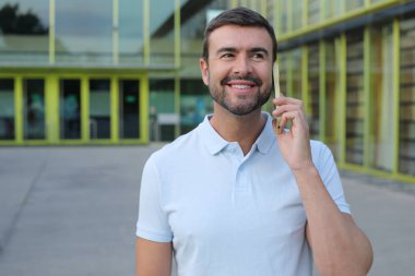 Dışarıda telefonla konuşan sakallı yakışıklı bir adamın portresi.