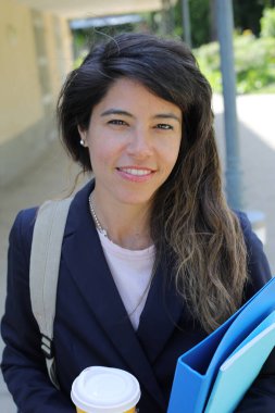 Dosyalar dolusu kahve taşıyan genç bir kadının portresi.