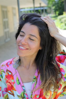 Mutlu genç kadın yaz elbisesi içinde poz veriyor.