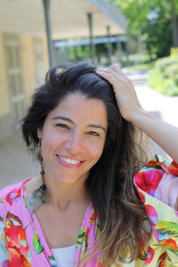 Mutlu genç kadın yaz elbisesi içinde poz veriyor.