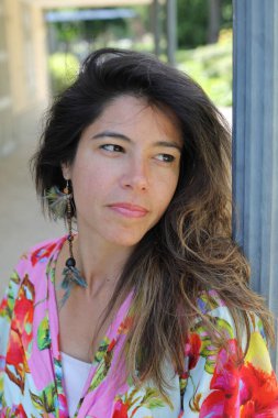 Mutlu genç kadın yaz elbisesi içinde poz veriyor.