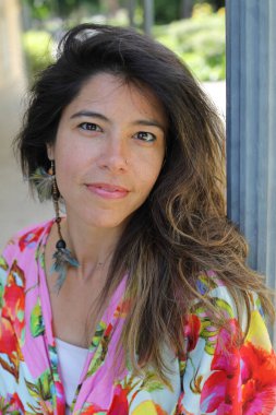 Mutlu genç kadın yaz elbisesi içinde poz veriyor.