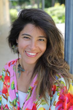 Mutlu genç kadın yaz elbisesi içinde poz veriyor.