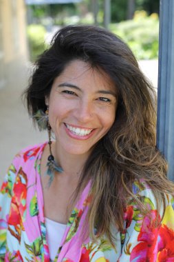 Mutlu genç kadın yaz elbisesi içinde poz veriyor.