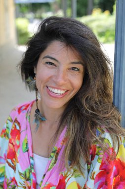 Mutlu genç kadın yaz elbisesi içinde poz veriyor.