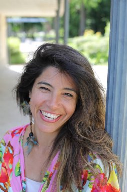 Mutlu genç kadın yaz elbisesi içinde poz veriyor.