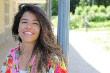 Mutlu genç kadın yaz elbisesi içinde poz veriyor.