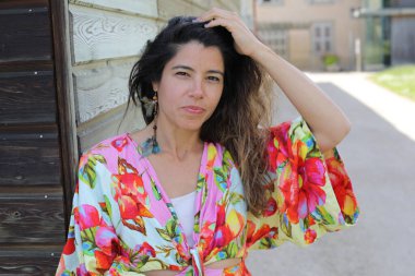 Mutlu genç kadın yaz elbisesi içinde poz veriyor.