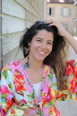 Mutlu genç kadın yaz elbisesi içinde poz veriyor.