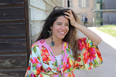 Mutlu genç kadın yaz elbisesi içinde poz veriyor.