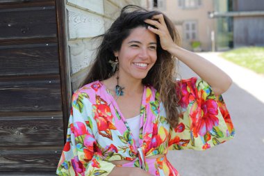 Mutlu genç kadın yaz elbisesi içinde poz veriyor.