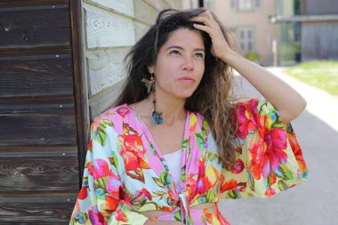 Mutlu genç kadın yaz elbisesi içinde poz veriyor.