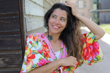 Mutlu genç kadın yaz elbisesi içinde poz veriyor.