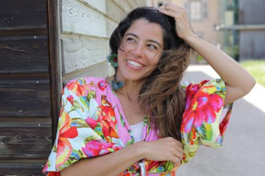 Mutlu genç kadın yaz elbisesi içinde poz veriyor.