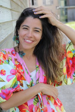 Mutlu genç kadın yaz elbisesi içinde poz veriyor.