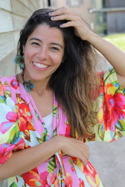 Mutlu genç kadın yaz elbisesi içinde poz veriyor.