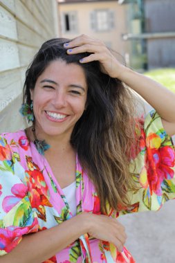 Mutlu genç kadın yaz elbisesi içinde poz veriyor.